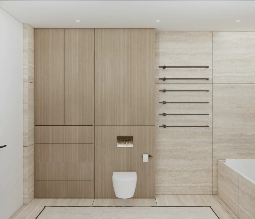 Przestrzeń toalety została sprytnie zaaranżowana w minimalistycznym stylu, z ukrytymi szafkami na przechowywanie. Pionowe, czarne grzejniki wprowadzają nowoczesny akcent, kontrastując z naturalnym kamieniem na ścianach.