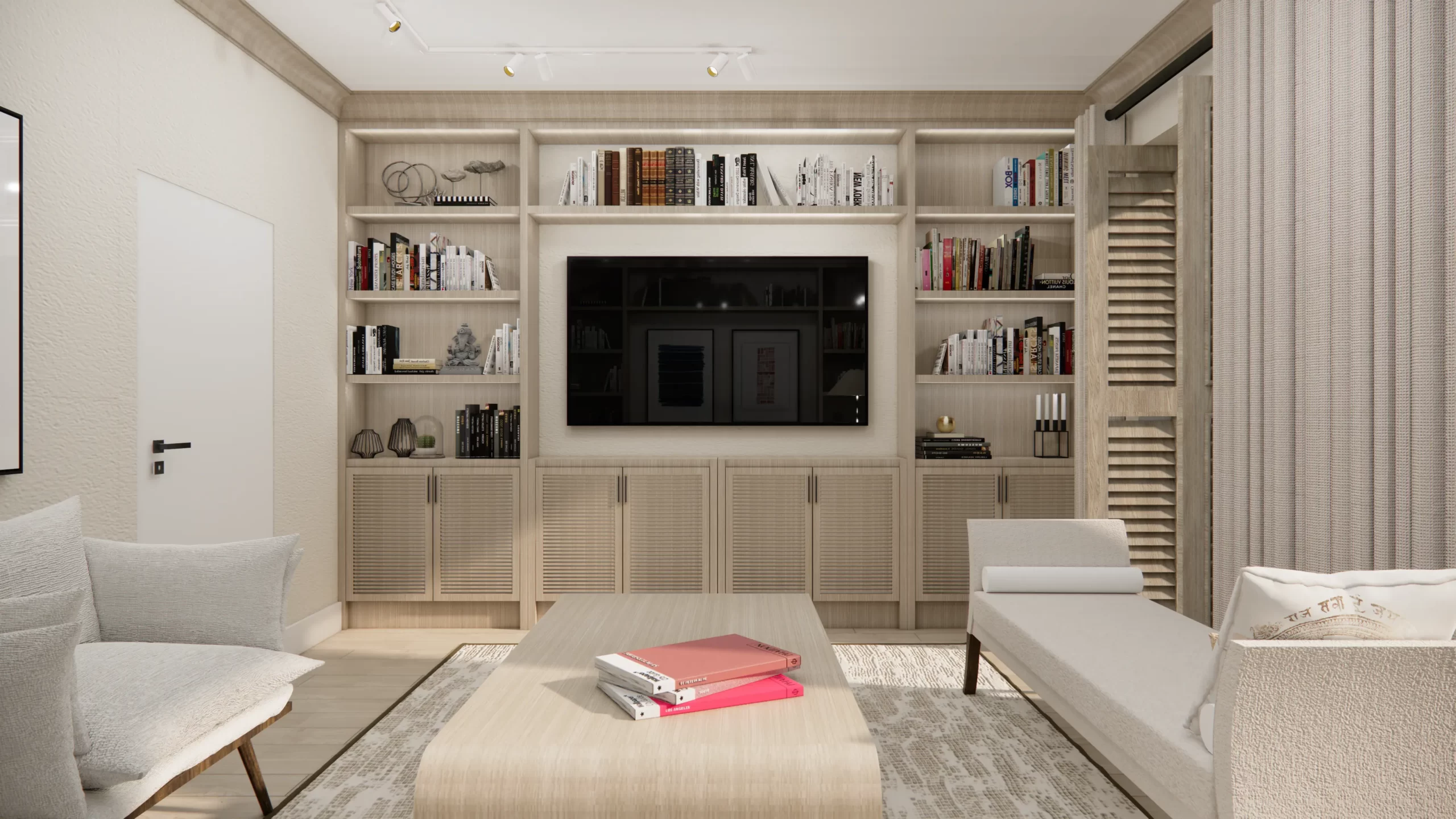 Wnętrze cechuje się jasną, neutralną kolorystyką, która nadaje przestrzeni lekkości i optycznie ją powiększa. W centrum znajduje się zabudowa z półkami, które są ozdobione książkami oraz dekoracjami, dodającymi wnętrzu osobistego charakteru. Telewizor został wkomponowany w środek zabudowy, tworząc funkcjonalną i estetyczną przestrzeń. Całość dopełniają proste, ale stylowe meble – jasne fotele i stolik kawowy, na którym spoczywają książki i magazyny w wyrazistych kolorach.